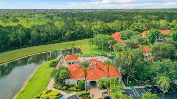 A resort with a swimming pool, palm trees, and a river. - 3BR Home: Family Retreat Near Disney (Kissimmee)
