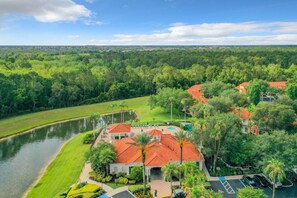 A resort with a swimming pool, palm trees, and a river. - Emerald Island 3BR Home + Resort Pool, Near Disney (Kissimmee)