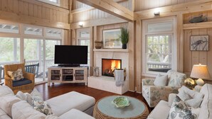 Un salón amplio con chimenea, asientos cómodos y televisor.