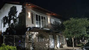 Une maison à deux étages, avec des fondations en pierre et un toit recouvert de tuiles.