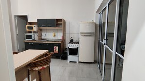 Une cuisine compacte équipée d’un four à micro-ondes, d’un grille-pain, d’une cuisinière et d’un réfrigérateur.