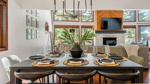 Comedor con una mesa de madera oscura dispuesta para seis personas, rodeada de sillas.