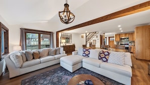 A spacious living area with a large sectional sofa, a dining table, and a kitchen in the background. - Washoe Way by Avantstay Luxury Tahoe Retreat A+ Location w/ Beach Access (Tahoe City)