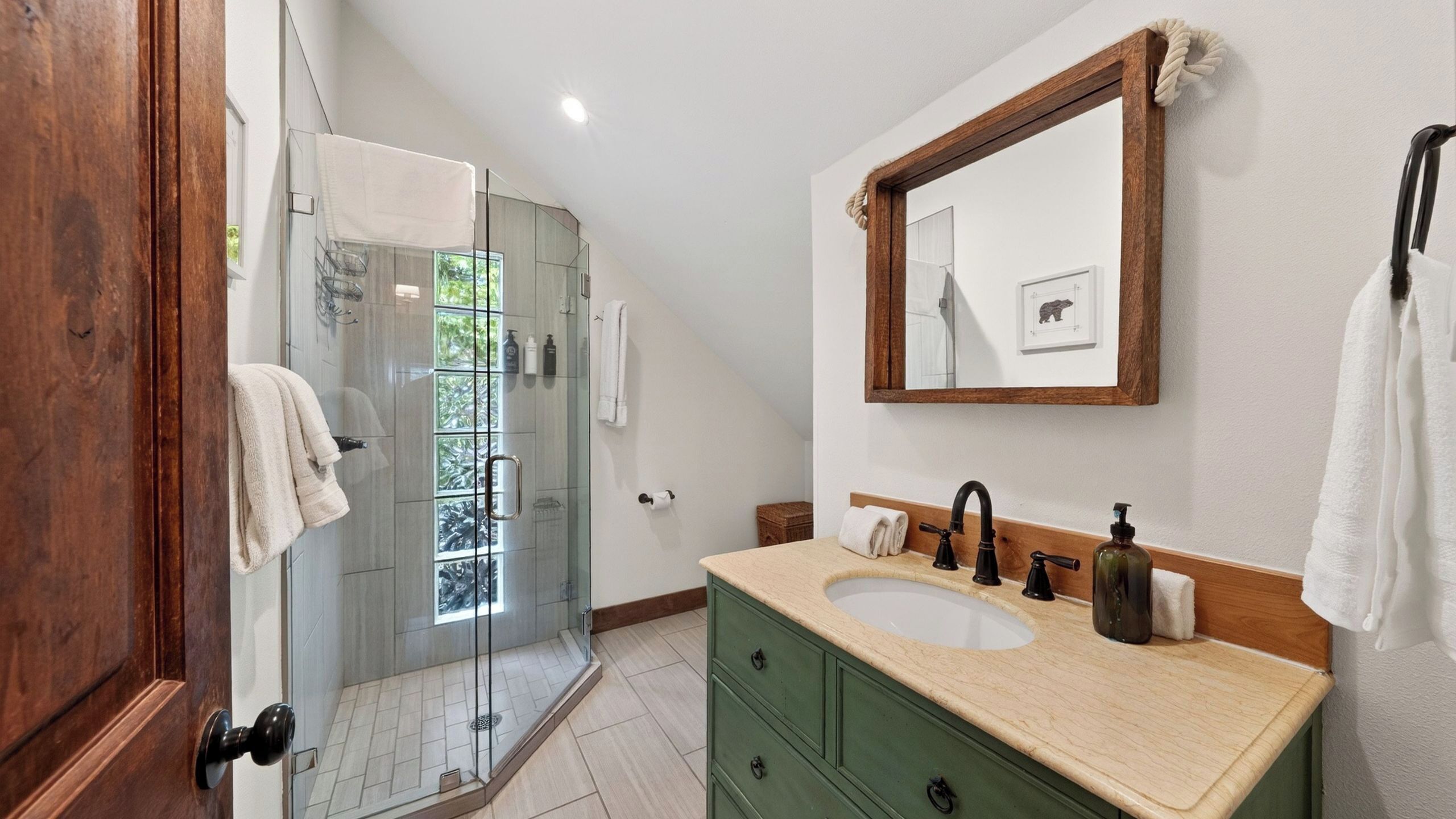 A bathroom with a double sink, a mirror, and a shower.