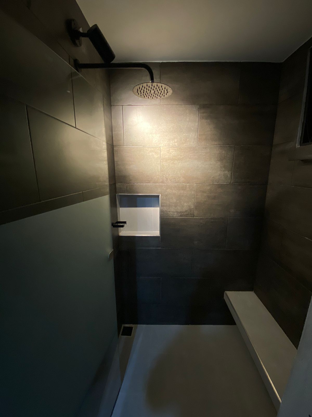 A modern bathroom with a shower, a sink, and a toilet.