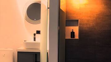 A modern bathroom with a toilet, sink, and shower area.