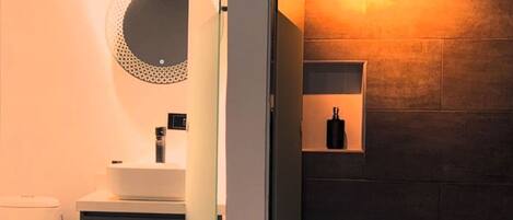 A modern bathroom with a toilet, sink, and shower area.