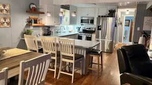 Una cocina moderna con armarios blancos, electrodomésticos de acero inoxidable y una isla central.