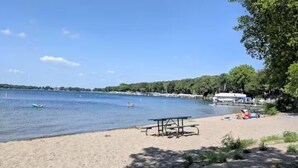 Una playa con una mesa de picnic y gente relajándose.
