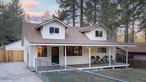 A two-story house with a covered porch and a fenced yard. - NEW! Hello Big Bear: Billiards, Airhockey, Firepit (Big Bear Lake)