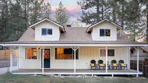 A two-story house with a covered porch and a fenced yard. - NEW! Hello Big Bear: Billiards, Airhockey, Firepit (Big Bear Lake)