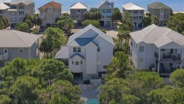 A coastal residential area with multiple houses, a swimming pool, and a view of the ocean.