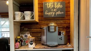 Una cocina de estilo vintage, con microondas, cafetera y repisas decorativas.