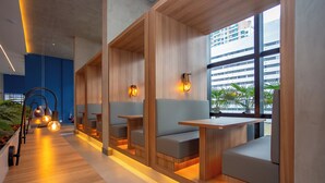 Ein modernes Interieur mit Holzwänden, gepolsterten Sitzgelegenheiten und Pendelleuchten.