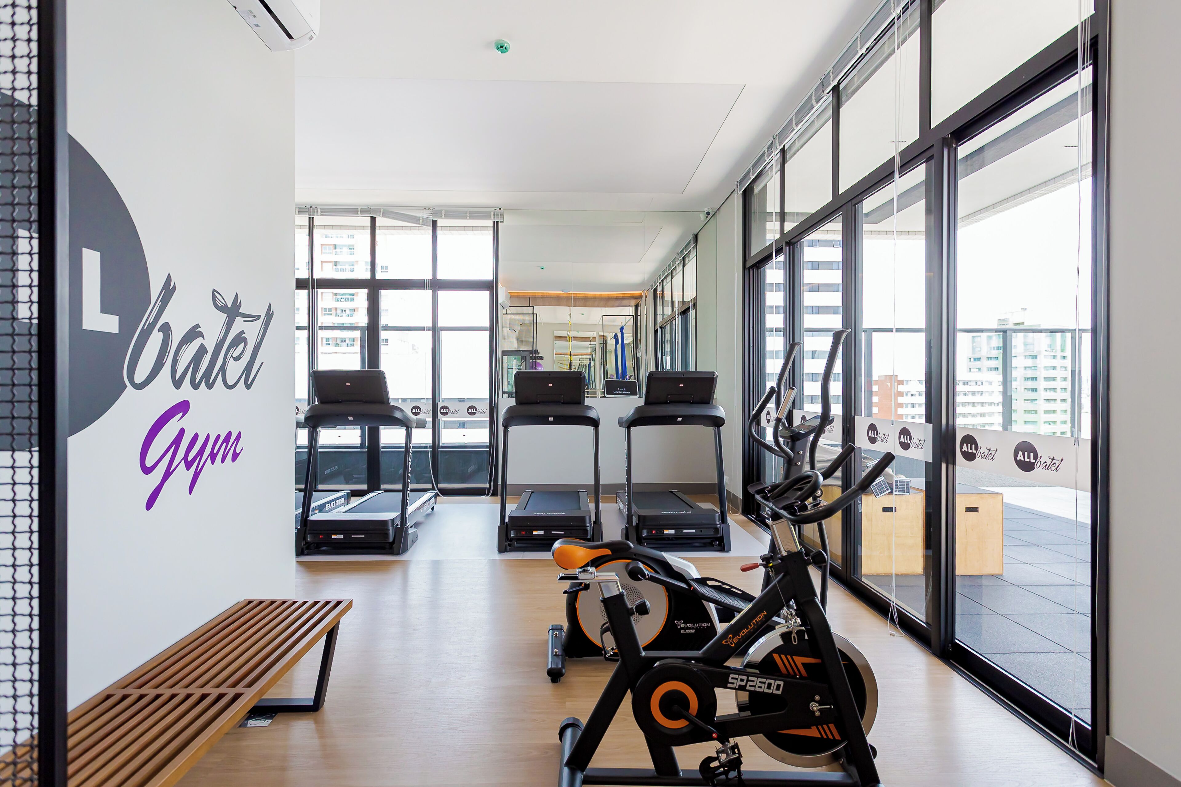 Ein Fitnessraum mit Laufbändern, Ergometer und einer Bank.