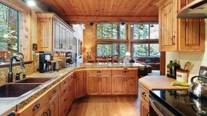Een ruime keuken met houten kastjes, granieten aanrechtbladen en een groot eiland.