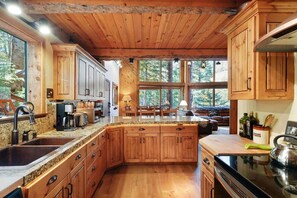 Una cocina amplia con armarios de madera, encimeras de granito y una isla grande.