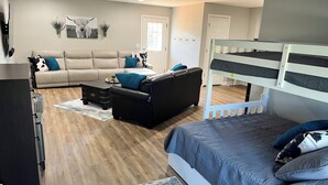 A modern bedroom with a bunk bed, a sofa, and a coffee table.