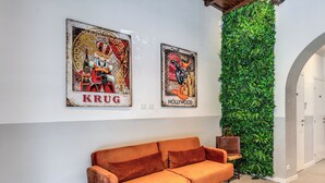 Ein modernes Interieur mit einer Couch, zwei Postern und einer vertikalen grünen Wand.