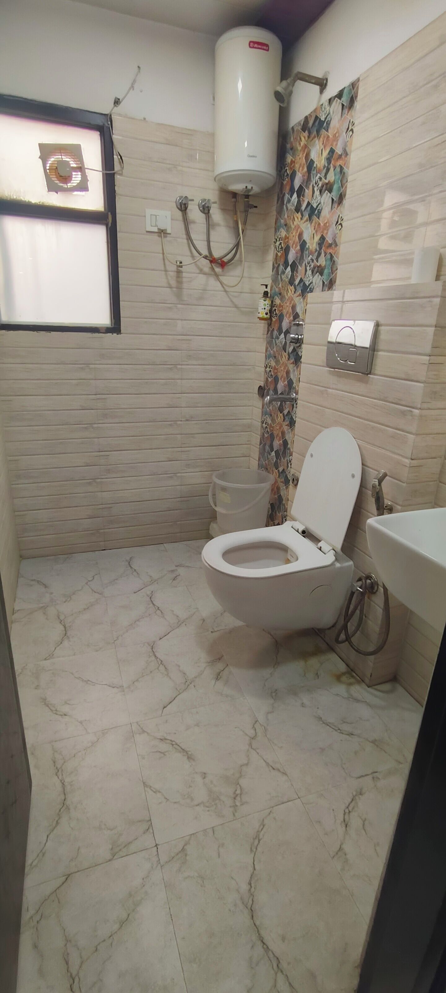 A bathroom with a toilet, a sink, a shower, and a water heater.
