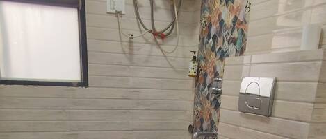 A bathroom with a toilet, a sink, a shower, and a water heater.