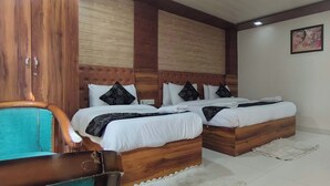 A bedroom with two wooden beds, a wooden wardrobe, and a blue chair. - Hotel Gloab Residency Near Delhi Airport (New Delhi)