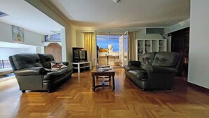 A spacious living room with a wooden parquet floor, two leather sofas, a coffee table, and a television. - Anno Domini Appia Antica 120 sqm, large,  elegant, close to the historic center (Roma)
