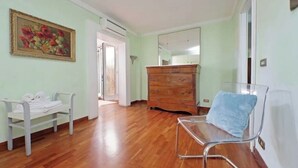 A room with a wooden dresser, a chair, a bench with towels, and a painting on the wall. - Anno Domini Appia Antica 120 sqm, large,  elegant, close to the historic center (Roma)