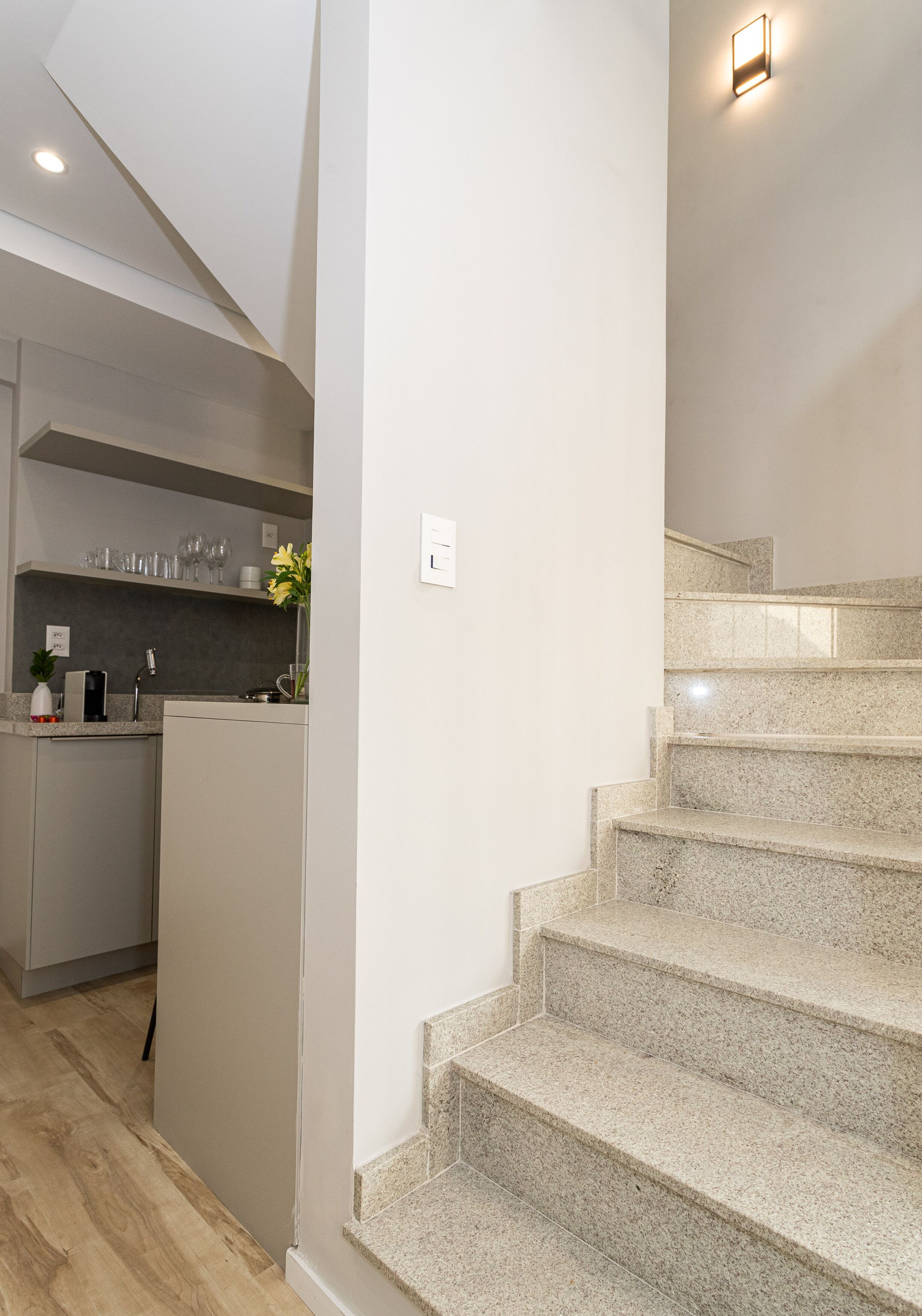 A modern kitchen with a built-in island, granite countertops, and a stainless steel range hood.