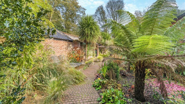 A garden pathway leading to a brick building with a tiled roof. - Blofield Cottage - UK48095 (Norwich)