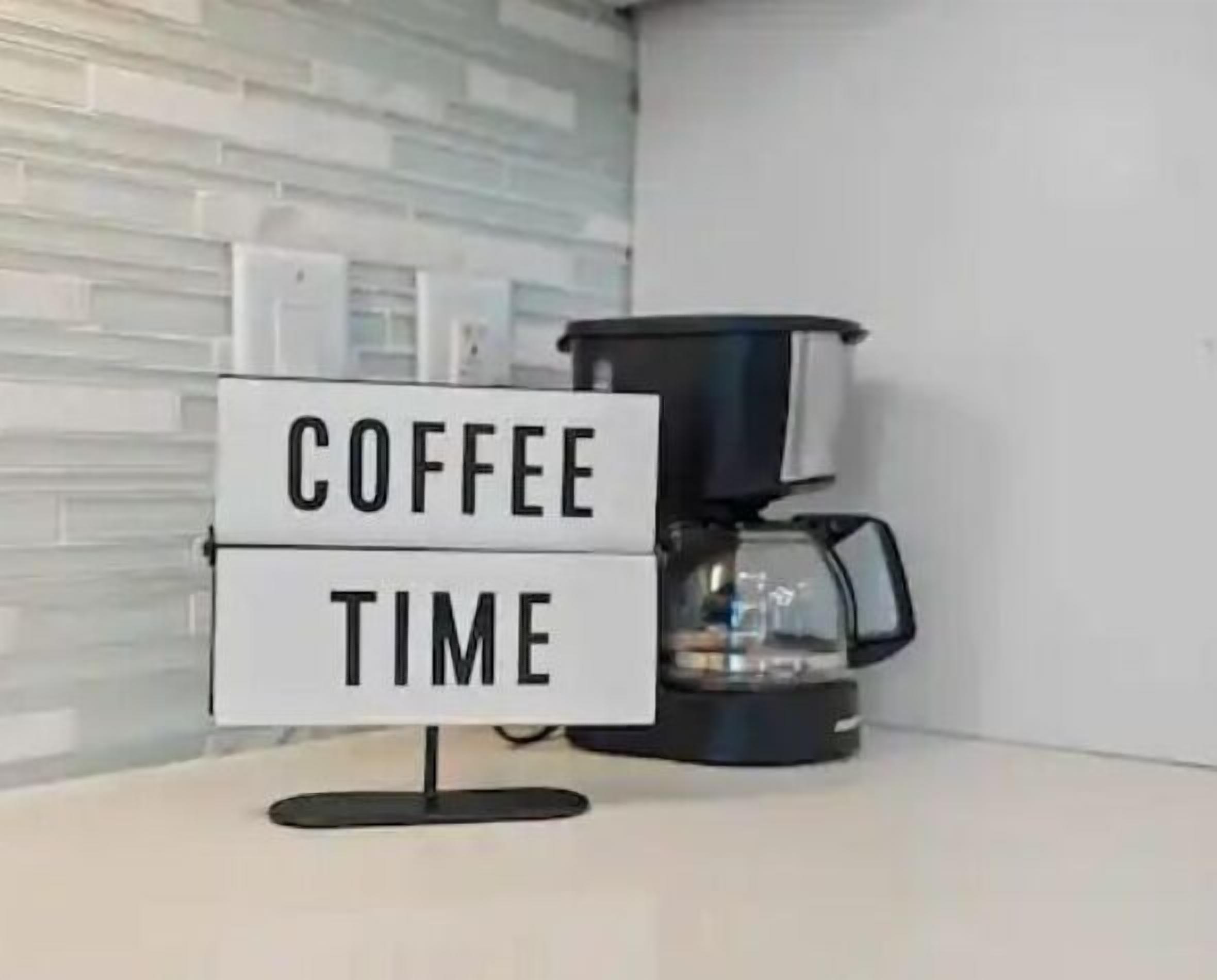 Una macchina da caffè con un cartello che dice 'COFFEE TIME' in una cucina moderna.