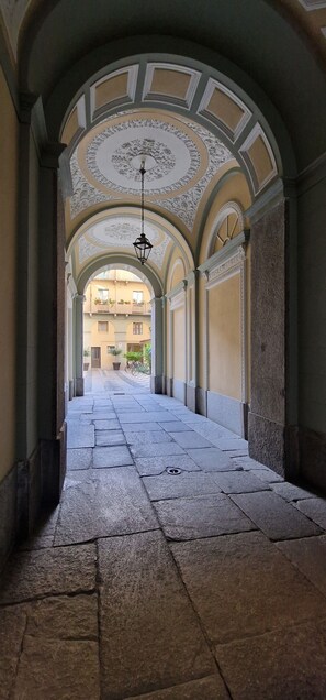 Un couloir doté d’un sol carrelé et d’un plafond orné.
