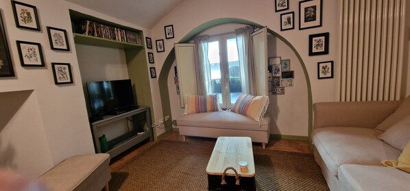 A cozy living room with a sofa, a coffee table, a TV, and a bookshelf. - Right in the center of Turin, 5 minutes from the Egyptian Museum and Porta Nuova (Torino)