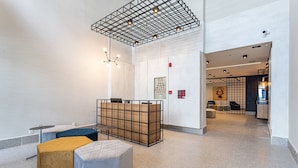 A modern lobby with a reception desk, seating area, and a high ceiling with exposed beams. - Zoom Santa Cecília by Viva - Prédio próximo à estação Marechal Deodoro e Fácil acesso ao Memorial da América Latina (São Paulo)