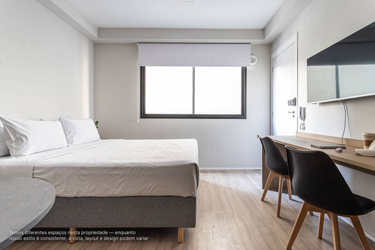 A modern bedroom with a bed, a desk, and a chair.