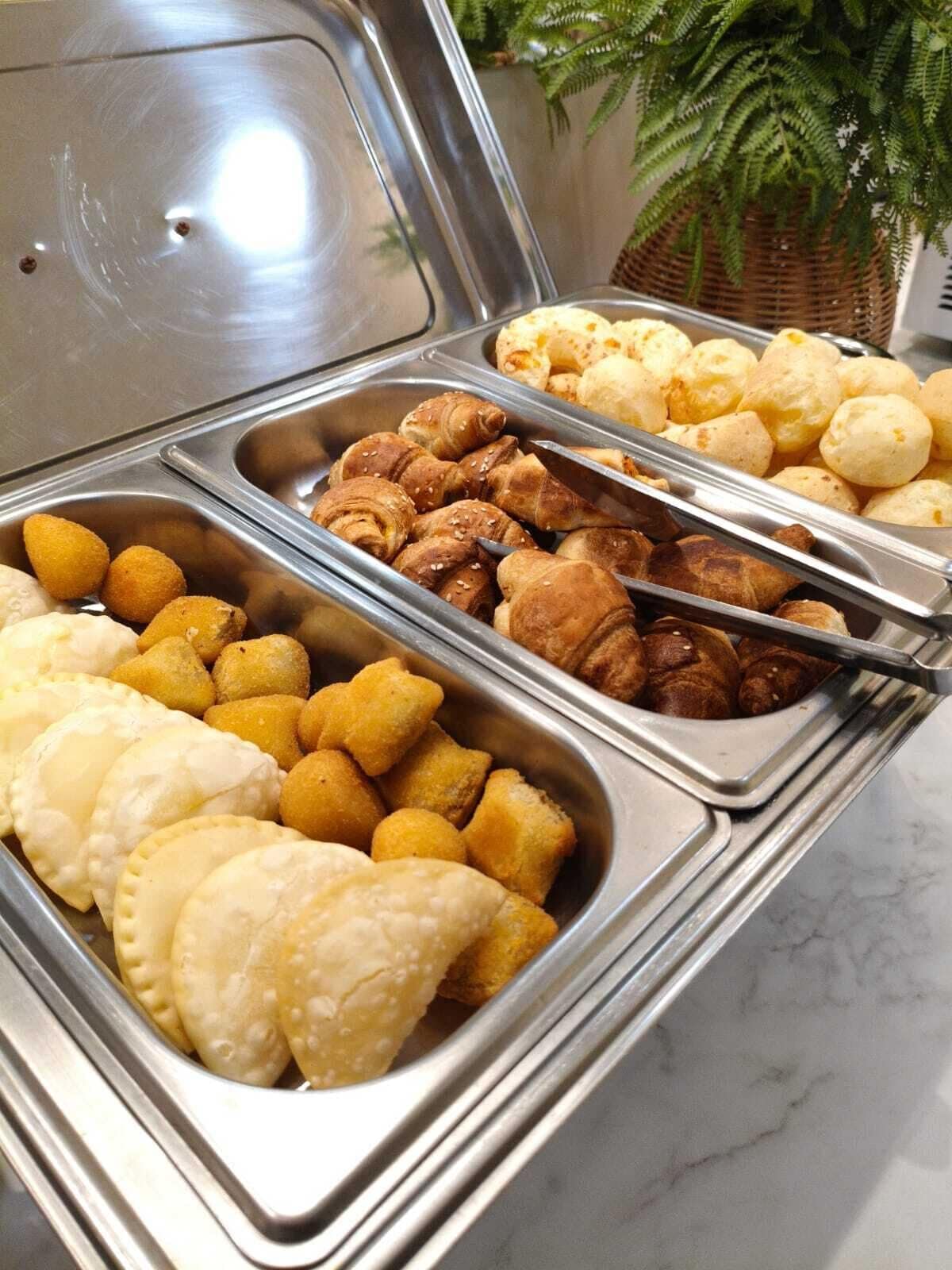 A buffet with various food items including pastries and bread.