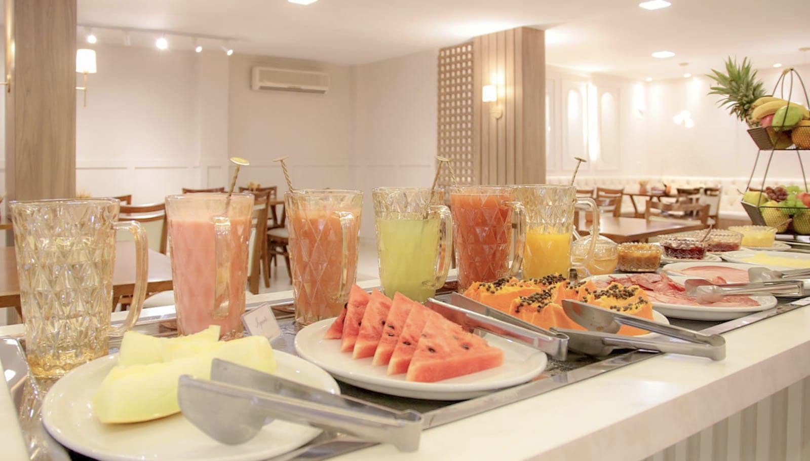 Un buffet proposant une variété de fruits, de jus et d’aliments pour le petit-déjeuner.