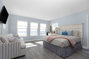 A bedroom with a bed, a sofa, and a TV. - Sunset View Beach House in Ocean Springs - Beachfront property (Ocean Springs)