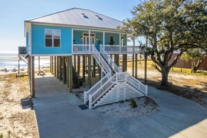 A two-story house with a balcony, a staircase, and a beach view. - Sunset View Beach House in Ocean Springs - Beachfront property (Ocean Springs)