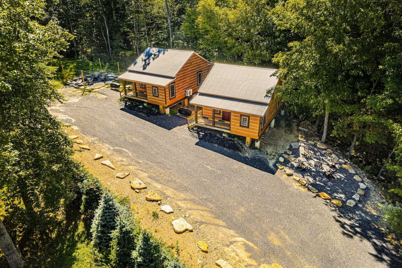 Une cabane avec une allée en gravier et un espace aménagé pour faire un feu de camp.