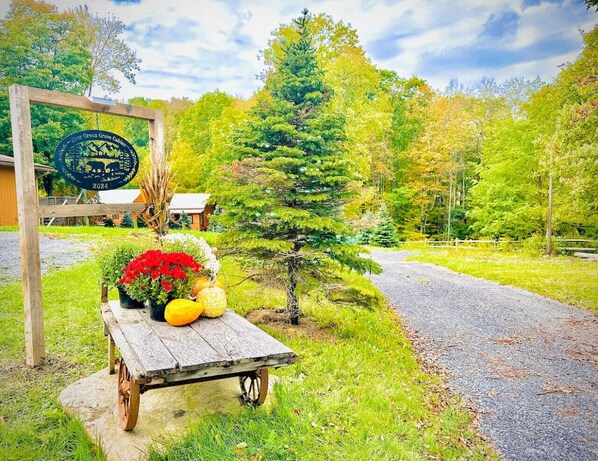 A wooden bench with potted plants and a sign in a garden setting.