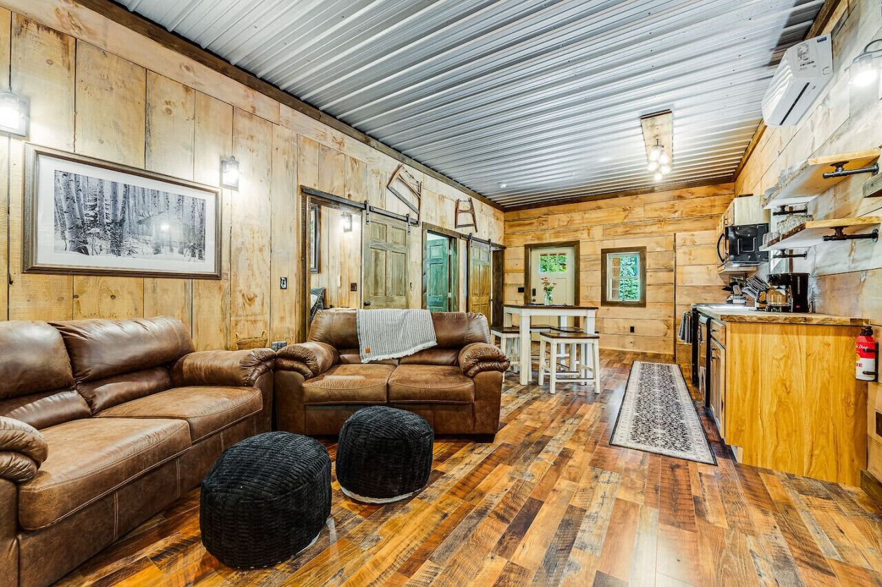 Un intérieur de chalet chaleureux avec des murs en bois, un coin repas et une petite cuisine.