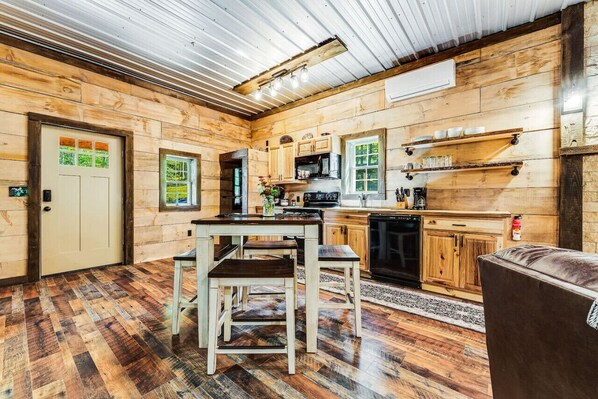 Een rustiek houten interieur met een keuken, houten vloeren en een eettafel met stoelen.