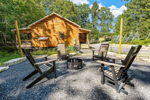 A rustic cabin with a fire pit and outdoor seating.