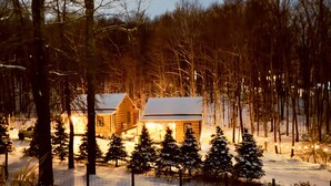A cabin surrounded by snow-covered trees and a fence. - EvergreenGrove-2 cabins/4BR (Oakland)
