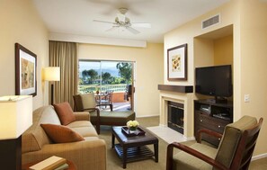 Relax in a warm and inviting space with a comfortable sofa, flat-screen TV, and fireplace.