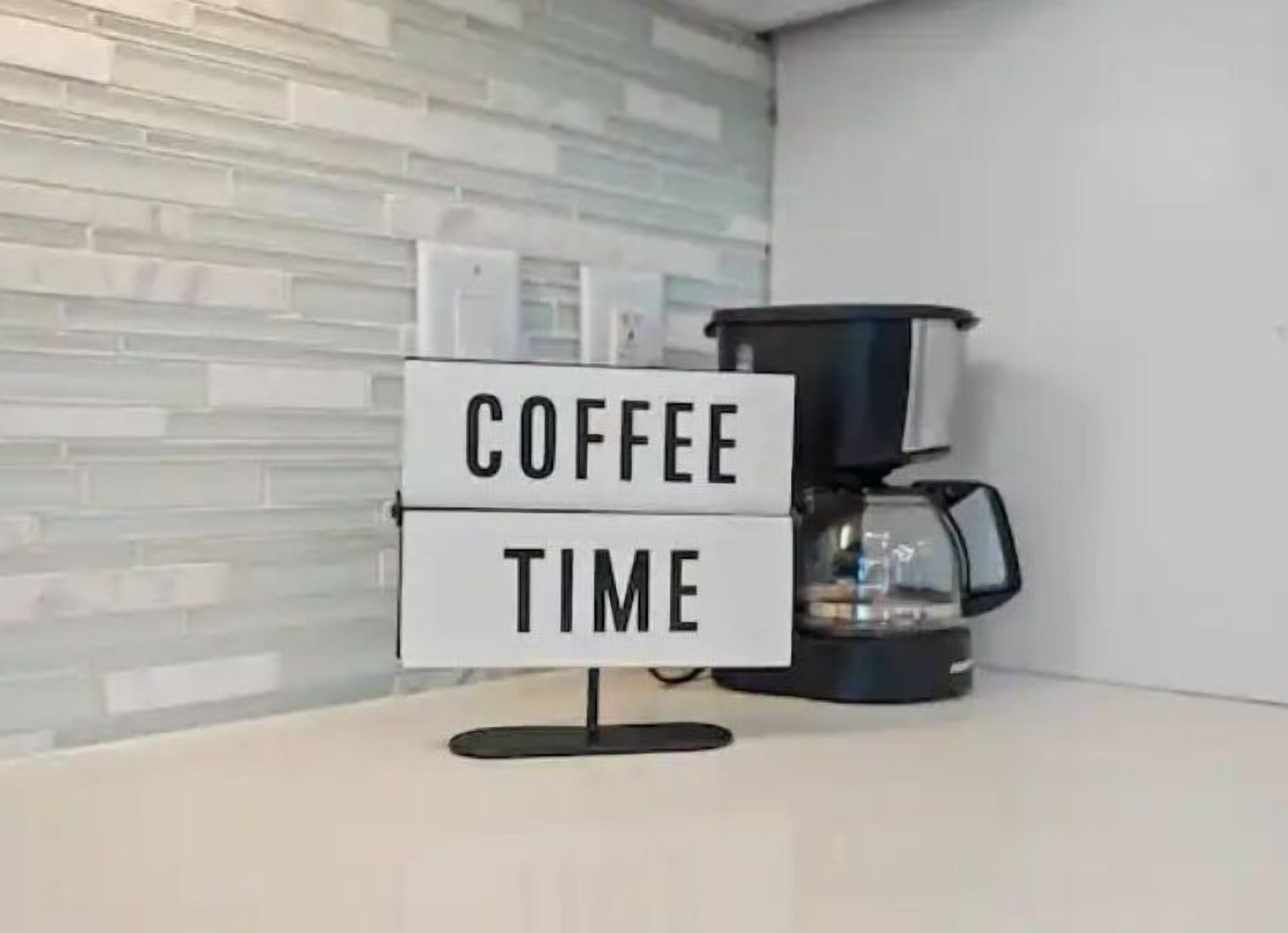 Une machine à café avec une pancarte indiquant «  COFFEE TIME », le tout dans un décor de cuisine moderne.