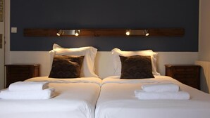 A double bed with white linens and two pillows, a wooden headboard, and two bedside tables with lamps. - Hôtel Au Grand Duquesne  (Dieppe)