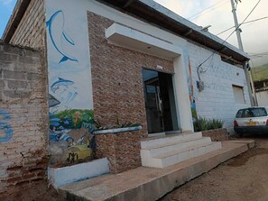 Un bâtiment à la façade en briques, orné d’une fresque représentant la vie marine sur le côté gauche.