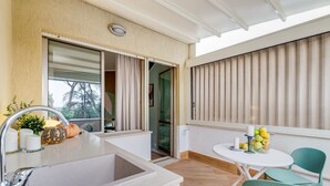 A modern kitchen with a sink, a window, and a table with chairs. - BDC - Cassia Luxury Studio (Roma)